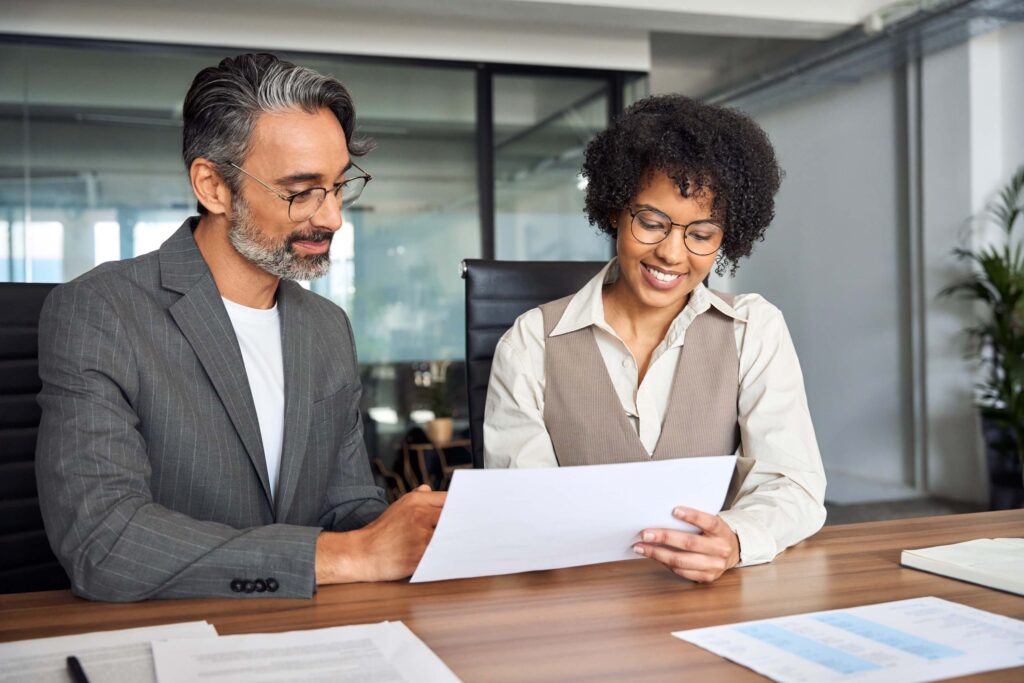 Financial advisor manager showing paper documents to client