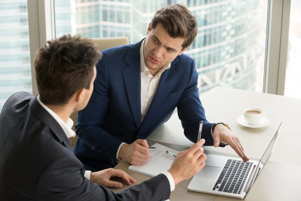 businesspeople using laptops and discussing a new project in the office
