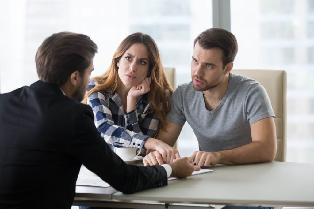 An angry and disgruntled couple arguing with a lawyer 