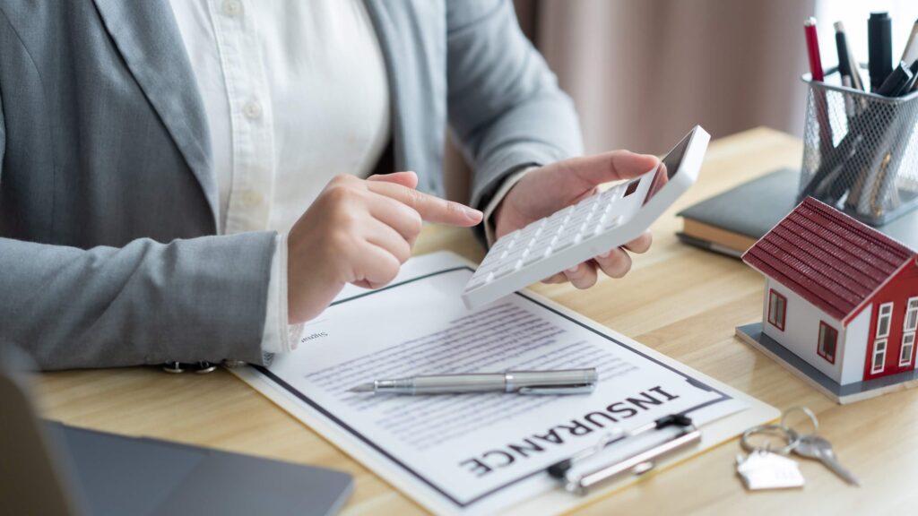 Insurance concept: real estate agent calculating the price of the property